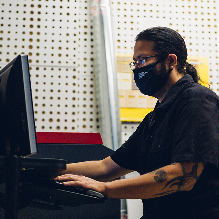 man wearing a mask working on computer
