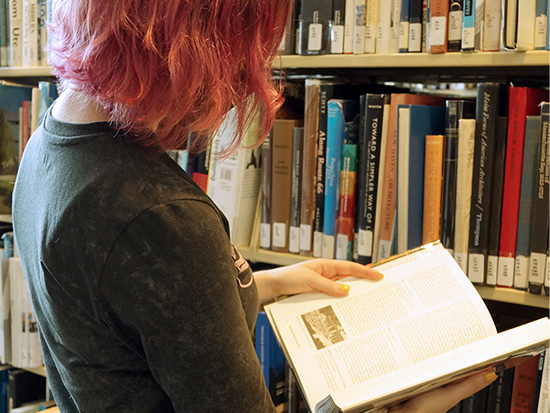 An over-the-shoulder view of a person reading a textbook