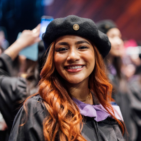 Graduating student smiles for the camera at the BAC Commencement Ceremony.