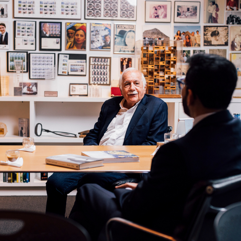 Moshe Safdie sits at his desk while speaking with BAC President Mahesh Daas.