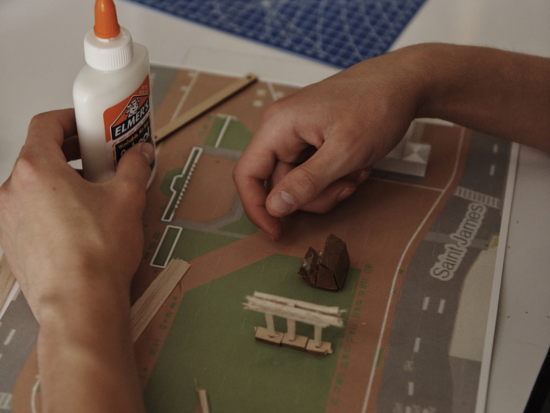 A BAC Summer Academy student's hands work to finish their diorama. 