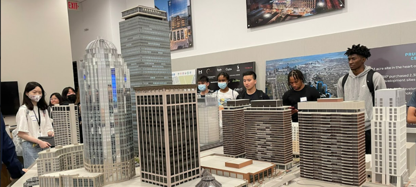 Urban Fellowship Students look at a scale module of skyscrapers while on a field trip to a firm.