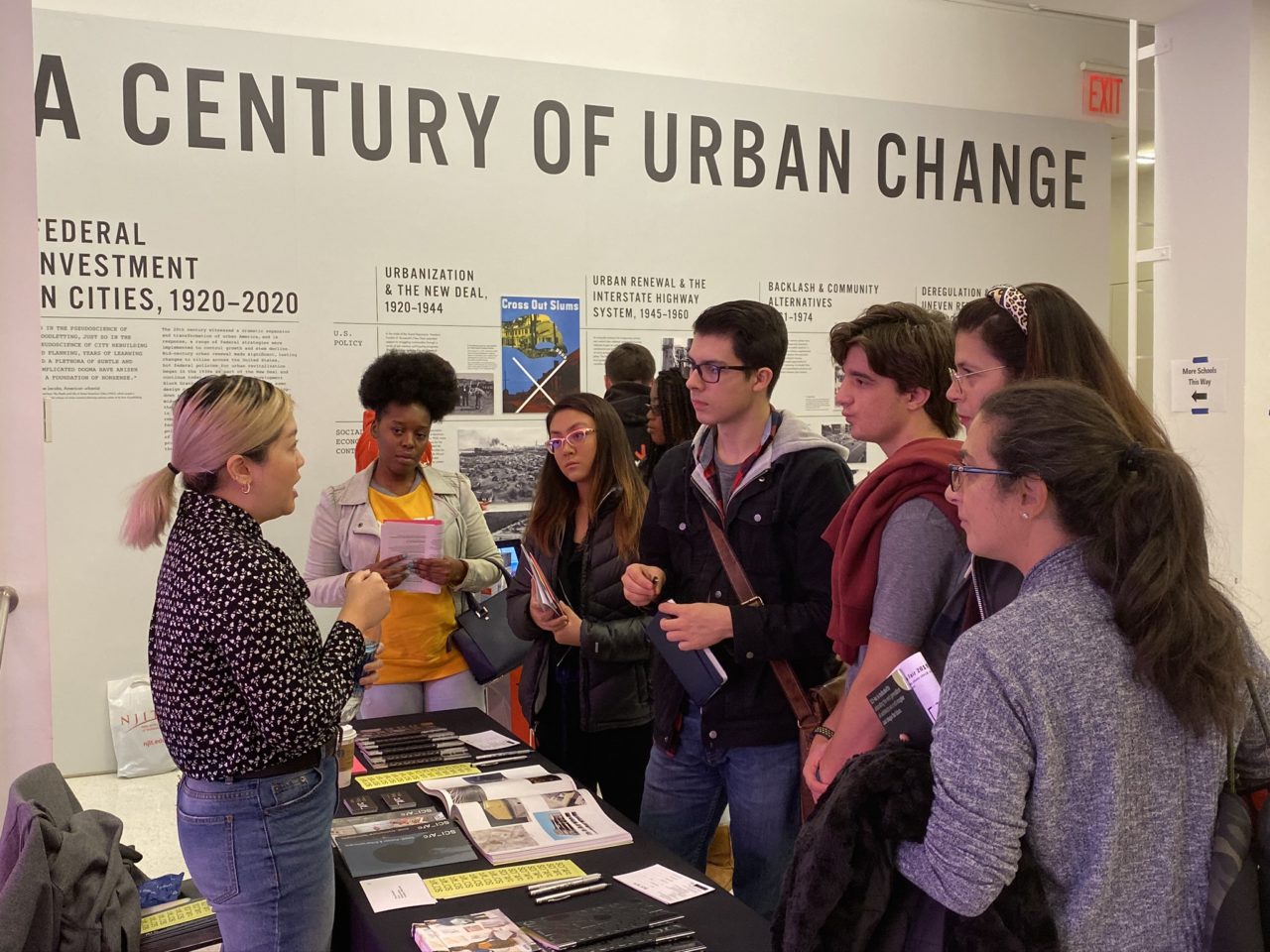 High school students and parents at a table speaking with a college representative.