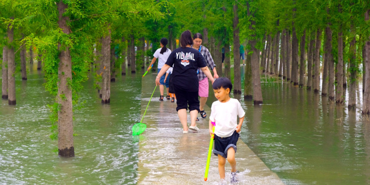 Children play along the water walkway in Zhengzhou Dongfengqu Ecological Cultural Park. Photo by Turenscape.