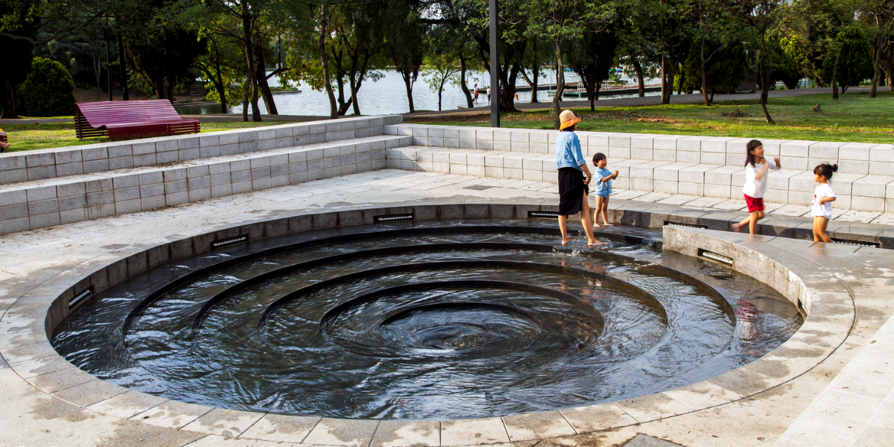 Circular vortex whirlpool fountain with spiraling water and surrounding stone seating in Chapultepec Forest, Mexico City.