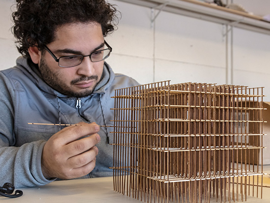 guy working on a wooden architecture model