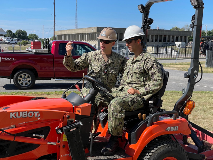 Hossein Abdavies listens to a fellow U.S. Navy officer and waits to drive a vehicle.