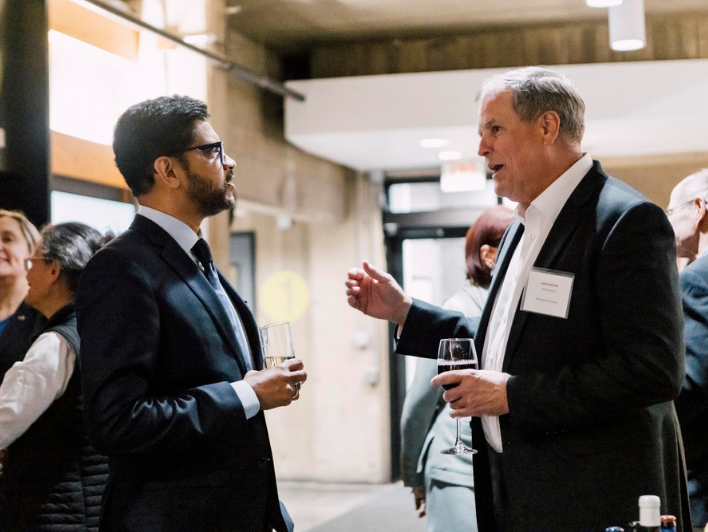 James Barrett speaking to President Mahesh Daas at a Board of Trustee event in the McCormick Gallery.