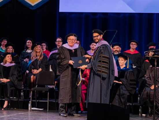 Richard Snyder receiving Honorary Doctorate with President Mahesh Daas at the 2024 Commencement Ceremony.