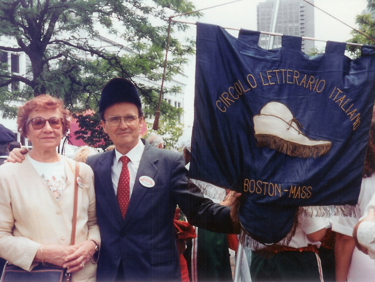 Franco and Maria, his wife, hold a flag embossed with 'Circolo Letterario Italiano. Boston - Mass.'